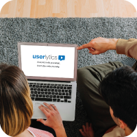 People looking at a computer while pointing at something.